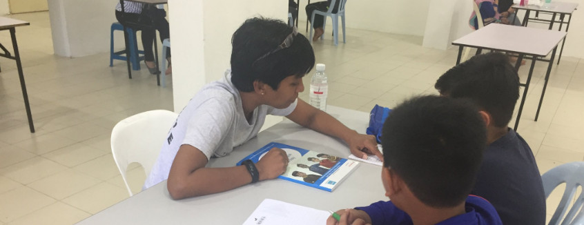 Volunteer to read with a child at Kerinchi Literacy Hub