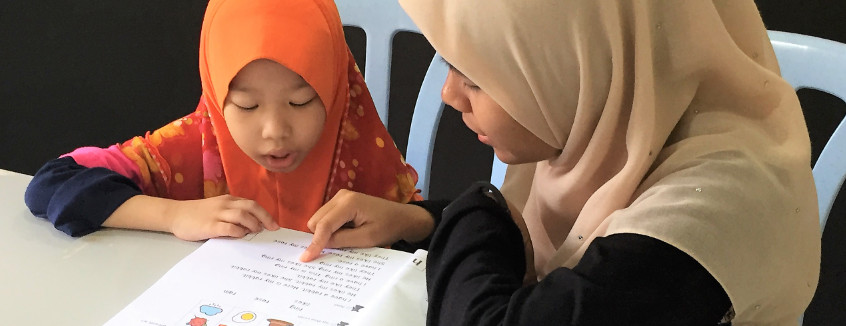 Volunteer to read with a child at Kerinchi Literacy Hub