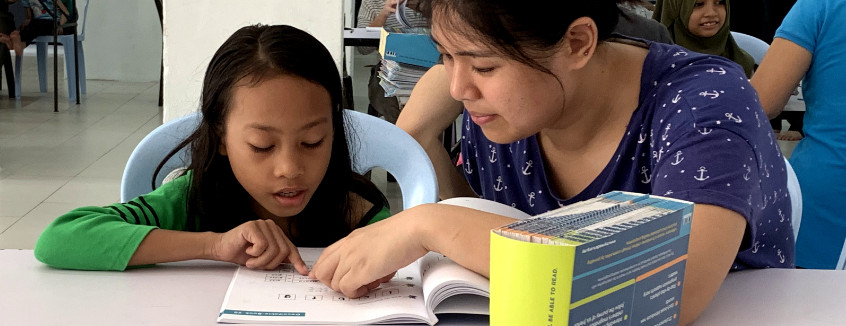 Volunteer to read with a child at Kerinchi Literacy Hub