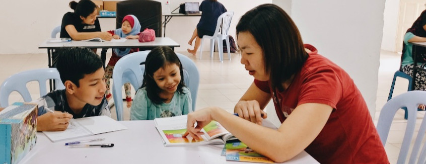 Volunteer to read with a child at Kerinchi Literacy Hub